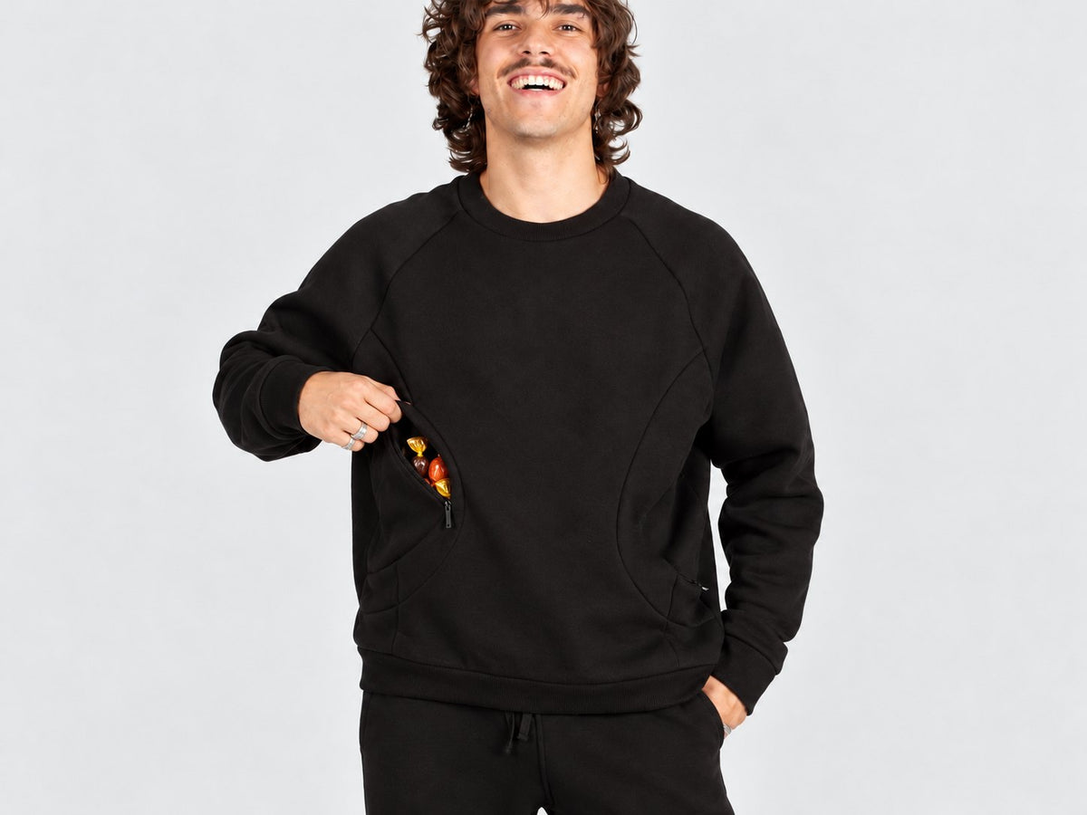 Eisdieler Späti Pocket Sweater in Schwarz, in der seitlichen Öffnung der doppellagigen Front stecken verpackte Bonbons (Motiv mit KI bearbeitet)